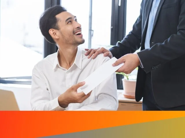 Man smiling handing over a paper